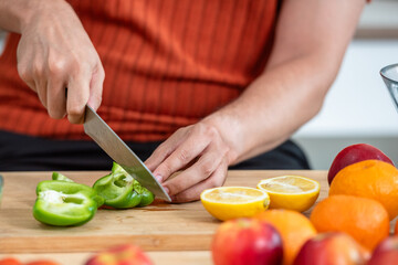 Hand chef knife cut and slice fresh Vegetables baby cos salad on wood board table .Make Salad Organic Vegetables mix lunch with green vegetables and fruit at kitchen table on wood cutting board.
