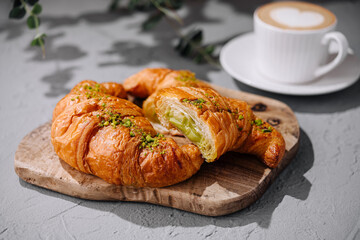 Fresh pistachio croissants and coffee on table