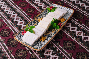 Traditional white cheese platter on ornate textile