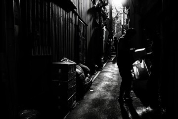 Clandestine world of urban smuggling, featuring individuals exchanging mysterious packages in the shadows of narrow alleyways. high-contrast black and white aesthetic.