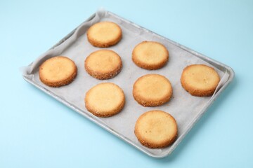 Tray with tasty sweet sugar cookies on light blue background