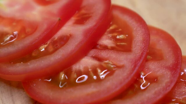 Sliced tomato on a wooden cutting board, close-up. Fresh red tomato slices