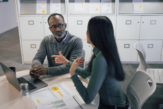 Mature African American businessman listening to a financial advisor in a business meeting