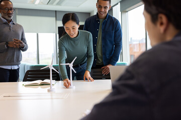 Team of engineers demonstrating wind turbine technology in a meeting