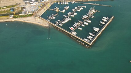Aerial view Yacht Club. Moored yachts and motorized private boats. The pier is made of wood....