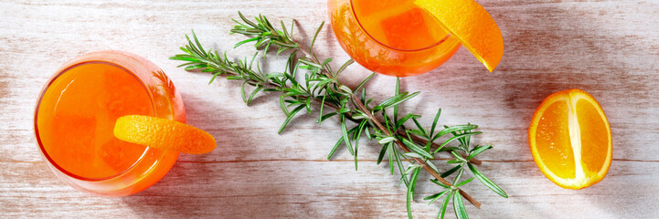 Orange cocktails with rosemary panorama, overhead flat lay shot on a wooden background