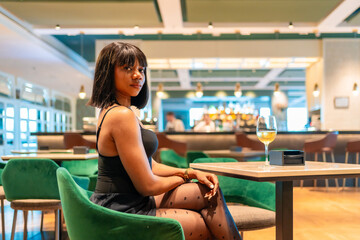 African woman in night sensual dress waiting in a restaurant