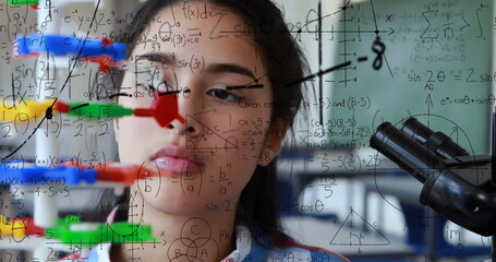 Image of mathematical formulae over student using microscope