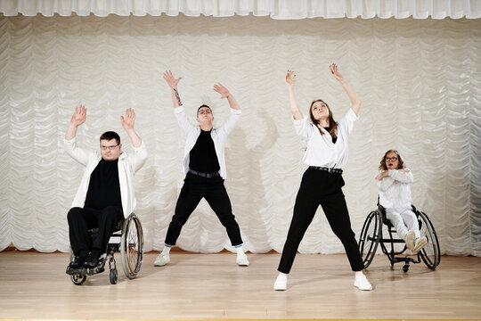 Group four diverse people performing contemporary wheelchair dance on stage, long shot, copy space - Powered by Adobe