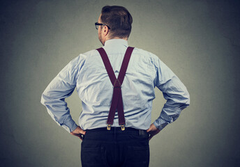 Back view of a business man standing and looking at a wall