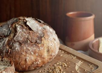 The round rye bread of the homemade bread is set against the background of a ceramic mug and a...