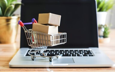 Online shopping concept with cart full of boxes on top of laptop computer, stock photo