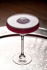 Cocktail in a martini glass on a dark background.