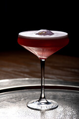 Cocktail in a martini glass on a dark background.