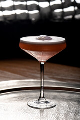 Cocktail in a martini glass on a dark background.