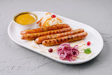 Grilled sausages with sauces and salad on plate