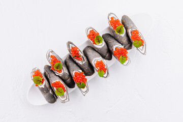 Elegant sushi set with red caviar and basil