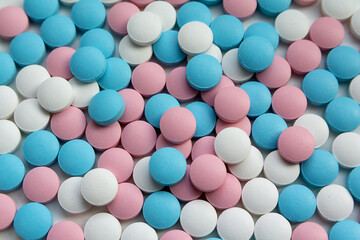 White, blue  and pink tablets scattering on the table