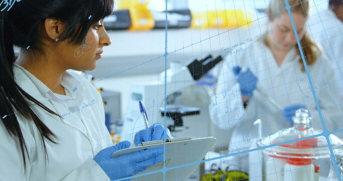 Image of mathematical equations over group of diverse scientists in lab