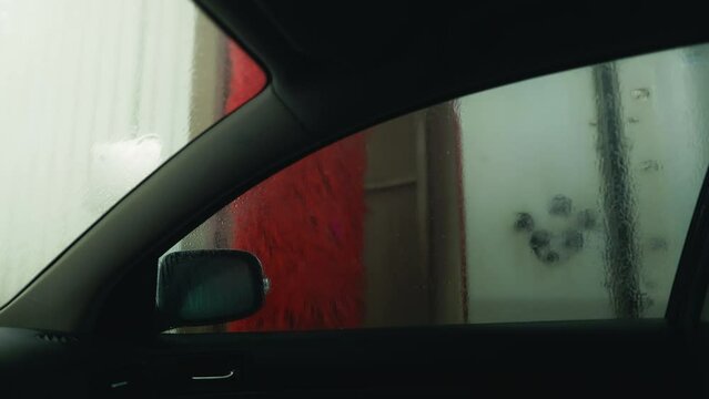 Inner Sanctum: Explore the serene world of an automatic car wash from inside the vehicle, as foam delicately embraces its exterior in enchanting slow motion.