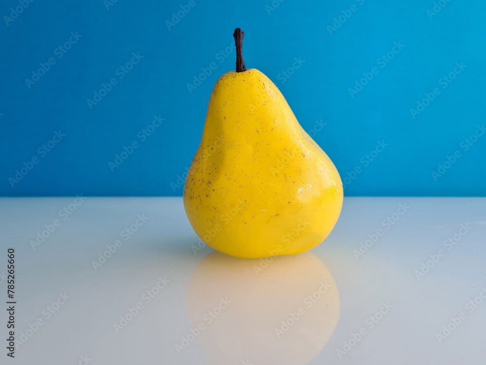 Wall mural yellow pear on white table