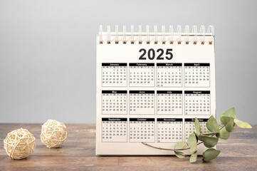 Calendar Year 2025 schedule. 2025 desk calendar notepad on wooden table and gray background. New Year. plans for 2025. gray background
