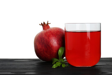 Refreshing pomegranate juice in glass, leaves and fruit on black wooden table against white...