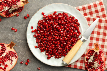 Tasty ripe pomegranate and grains on grey table, flat lay