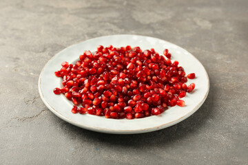 Tasty ripe pomegranate grains on grey table