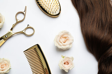 Flat lay composition with different hairdresser tools and flowers on white background