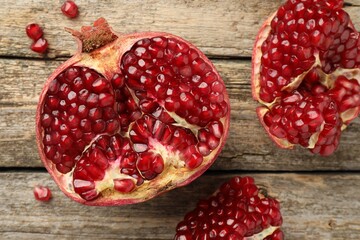 Cut fresh pomegranate on wooden table, top view