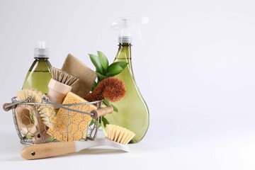 Set of different cleaning supplies in basket on white background