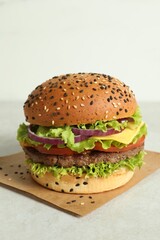 Burger with delicious patty on light table