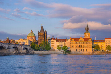 View of old town with Charles Bridge (Karluv Most) on Vltava river and Old Town Bridge Tower, famous tourist destination in Prague, Czech Republic (Czechia), at sunset