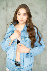 beautiful young woman with long hair in jeans and jacket posing
