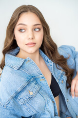 beautiful young woman with long hair in jeans and jacket posing