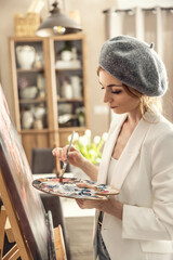 Beautiful female painter enjoying while painting in home art studio. Woman Artist Works on Abstract acrylic painting in the art studio - 785283624