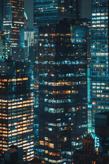 Obraz premium A closeup of skyscrapers in a city during nighttime using a telephoto lens