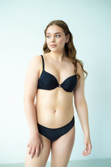 Fototapeta premium young woman with beautiful hair in black lingerie posing isolated on white background. Model test, snap, polaroid