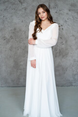 portrait of beautiful young woman in white wedding dress posing in studio.