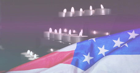 Image of light trails over candles and flag of usa