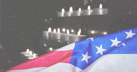 Image of snow falling over candles and flag of usa