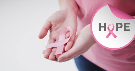 Image of hope text over caucasian woman with pink ribbon on white background