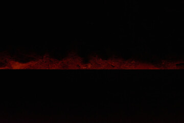 A silent fire burns in the semi darkness its red light painting dancing shadows inviting reflection...