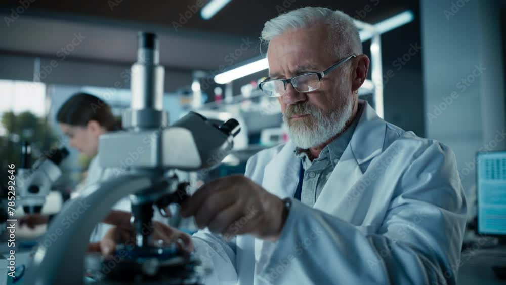 Poster senior medical research scientist looking at biological samples under a microscope in an applied sci