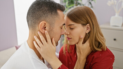 A loving couple embracing in a cozy bedroom, conveying warmth and affection in an intimate indoor...