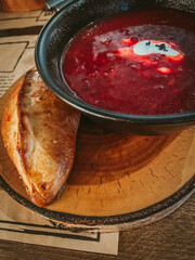 Red soup with cream and bakery products.Traditional Ukrainian Russian borscht . Bowl of red beet root soup borsch with white cream . Beet Root delicious soup . Traditional Ukraine food cuisine