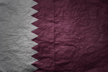 big national flag of qatar on a grunge old paper texture background