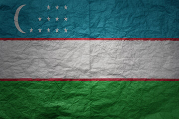 big national flag of uzbekistan on a grunge old paper texture background