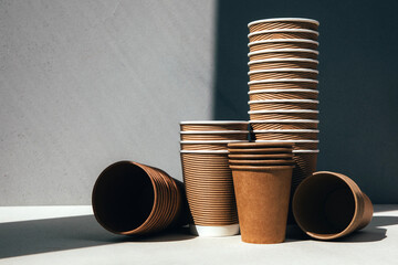 A set of paper utensils, paper cups on a gray background. Eco friendly, zero waste concept. Front...